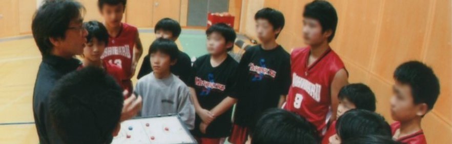 小学生にバスケットボールを指導している制作者の様子